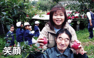 入居者と職員が果物狩りを楽しむ施設の外出レクリエーション風景