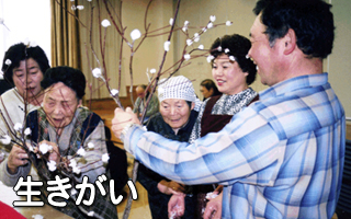 入居者と職員が正月飾りを前に笑顔で交流する風景